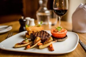 Grilled steak main course served with seasonal vegetables at Holdsworth House restaurant.