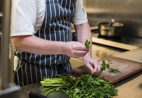 Chef preparing fresh herbs in the kitchen at Holdsworth House restaurant, Halifax.