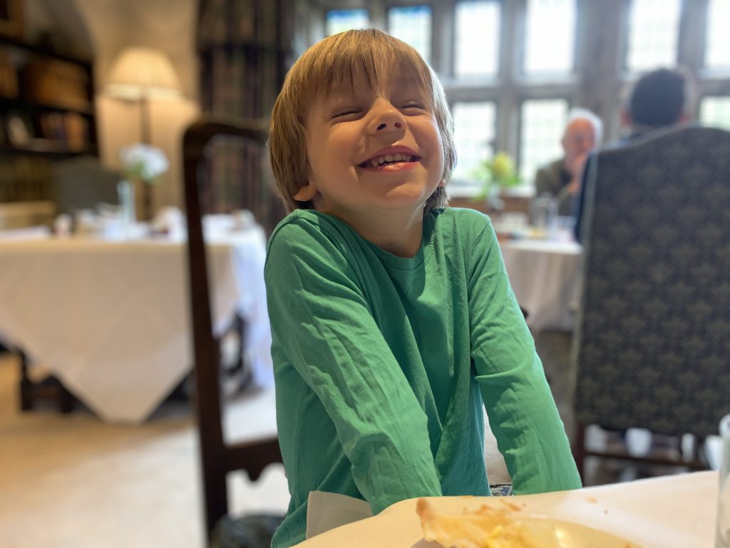 Child smiling whilst eating afternoon tea at Hodlsworth House in Halifax
