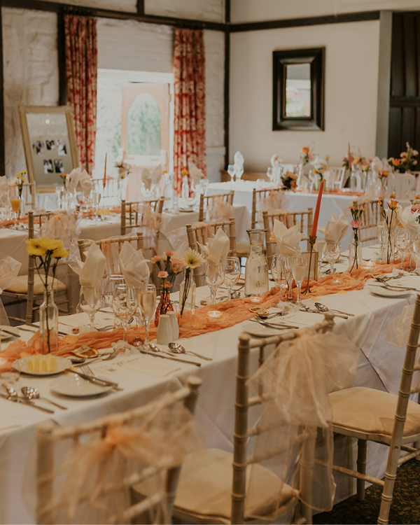 Elegant wedding reception table setting with floral centrepieces and candles at Holdsworth House, Halifax.