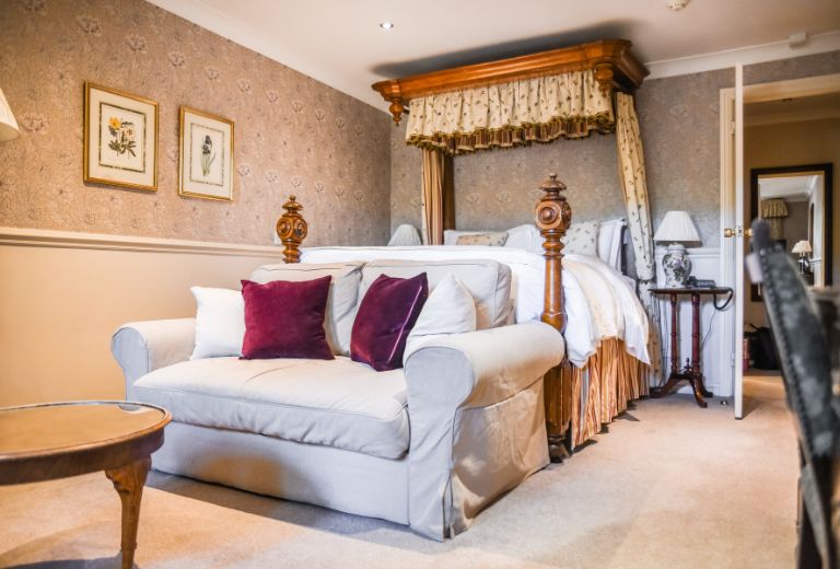 Luxurious double bedroom with a canopy bed and elegant furnishings at Holdsworth House Hotel.