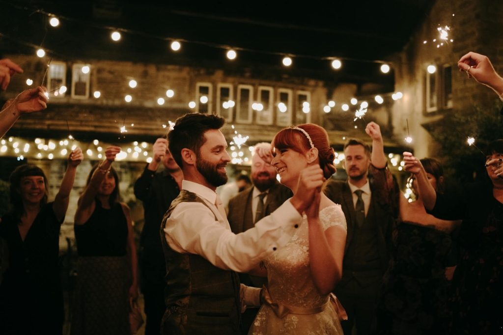 Wedding couple dancing in the courtyard at Holdsworth House in the evening.