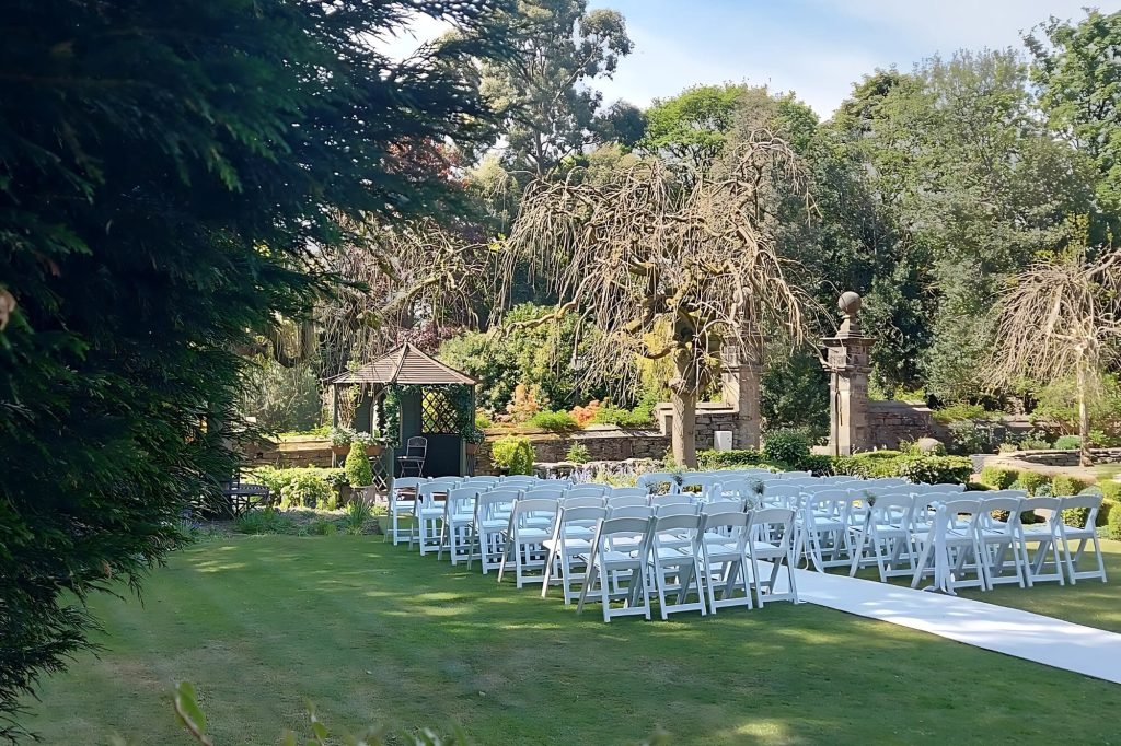 Outdoor wedding ceremony set up in the gardens at Holdsworth House.