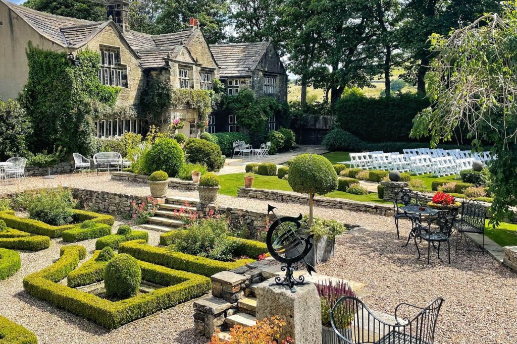 Wedding ceremony seating arranged in the gardens at Holdsworth House.