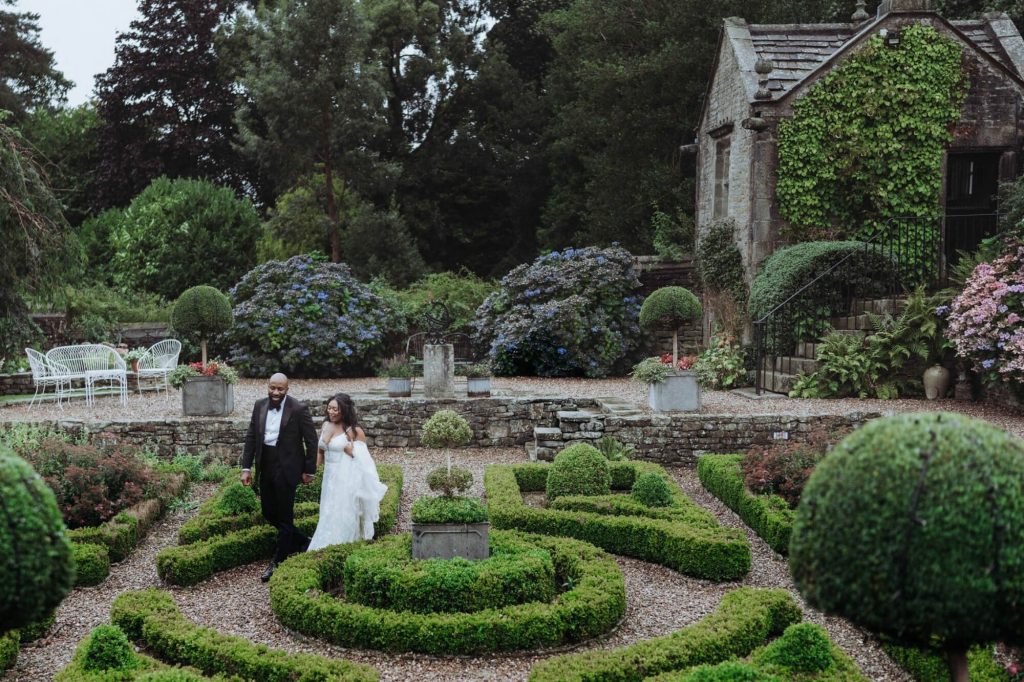 Wedding couple walking together through the gardens at Holdsworth House.