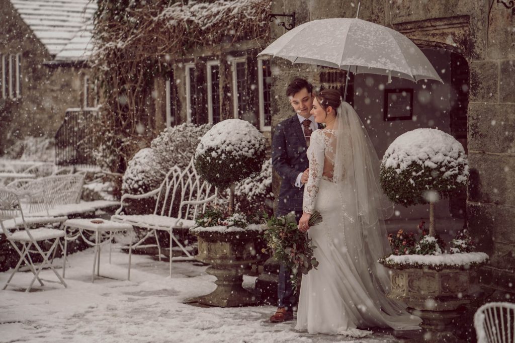Winter wedding couple standing together in the courtyard at Holdsworth House.