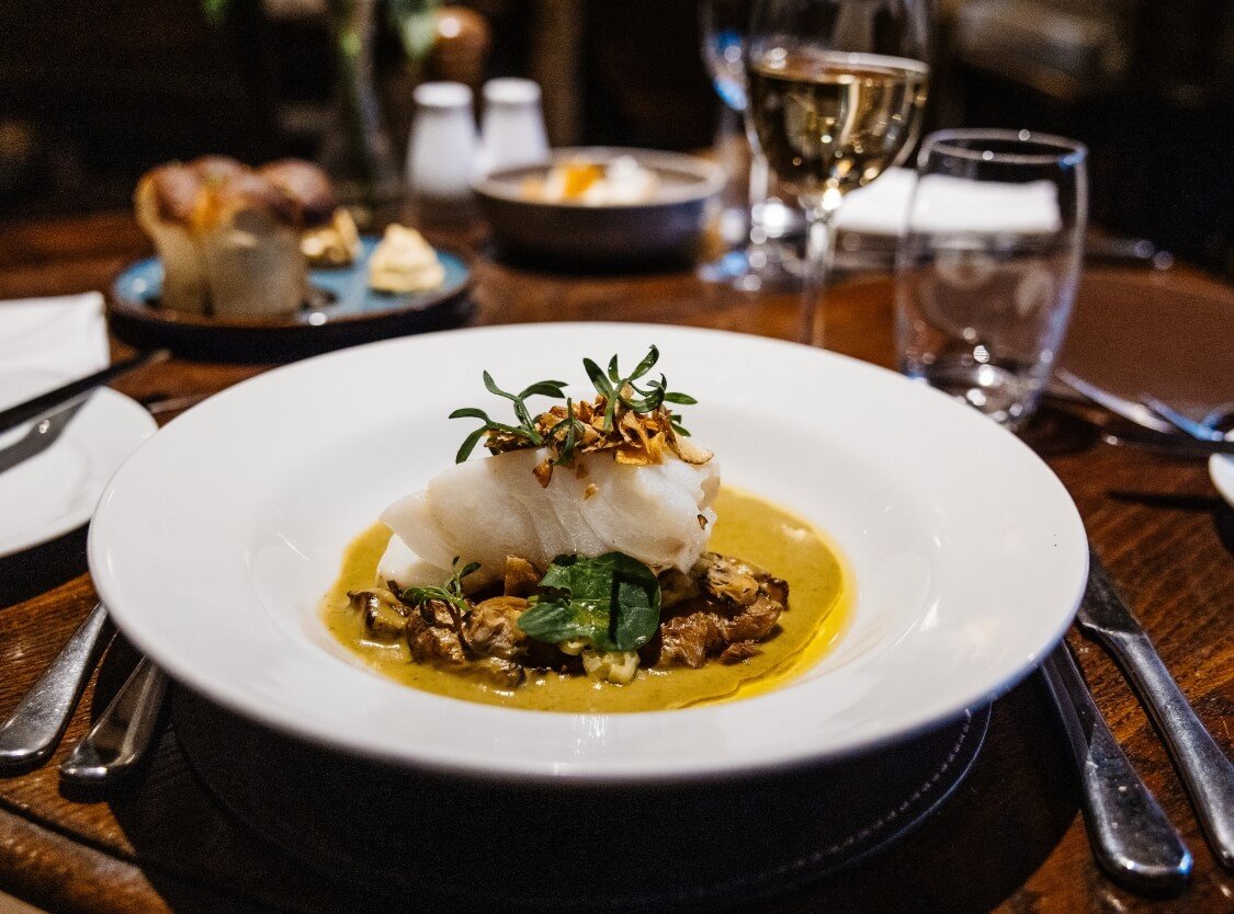 large fish main curse in the restaurant at Holdsworth House and a glass of drink
