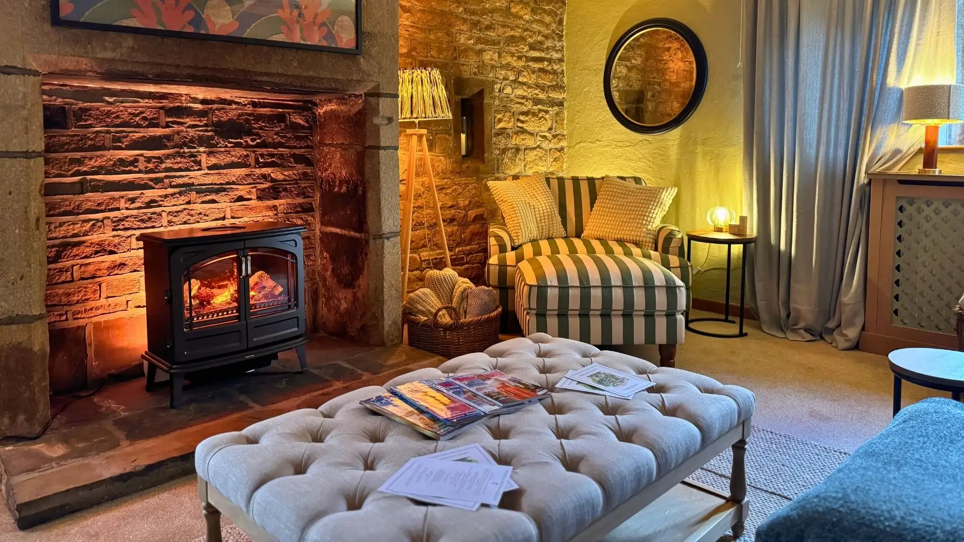 The relaxation lounge at The Farmhouse, the log burner lit