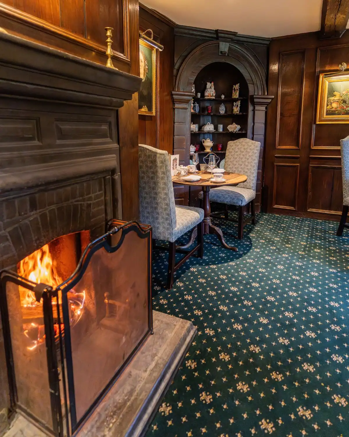A table laid for dinner beside the lit fire in the restaurant at Holdsworth House, Halifax