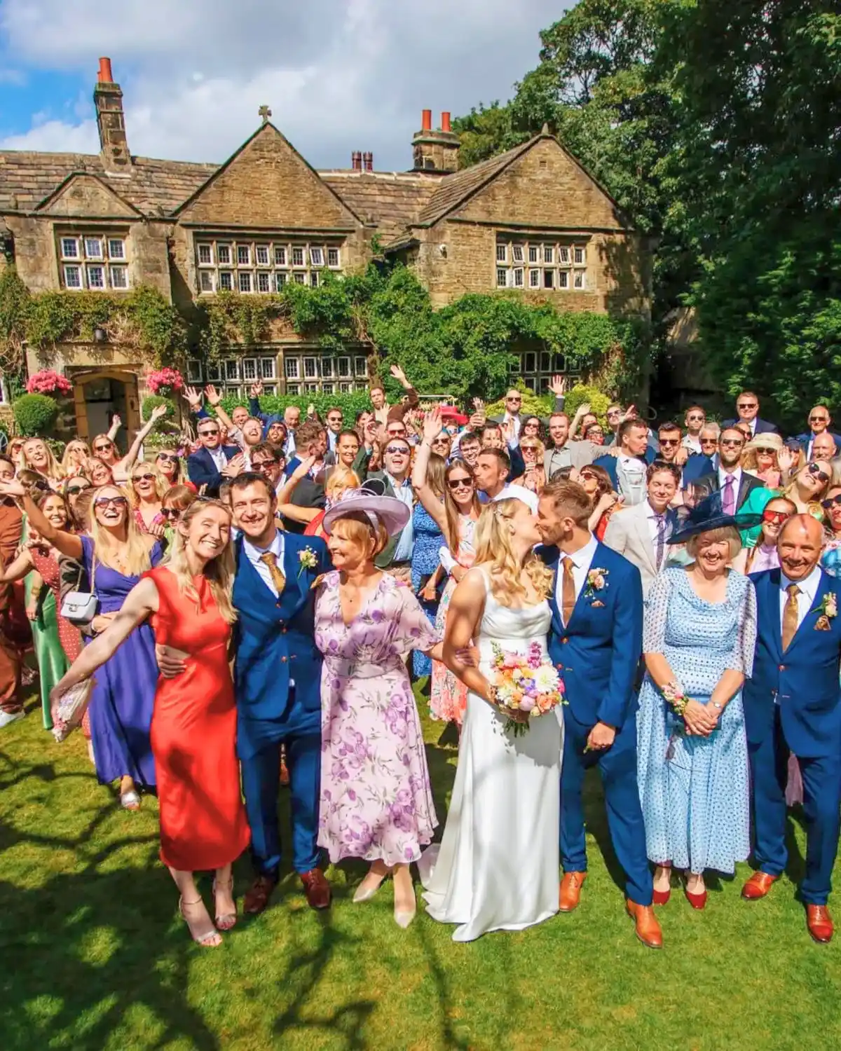 A wedding party on the lawn in front of Holdsworth House, a wedding venue in Halifax, West Yorkshire